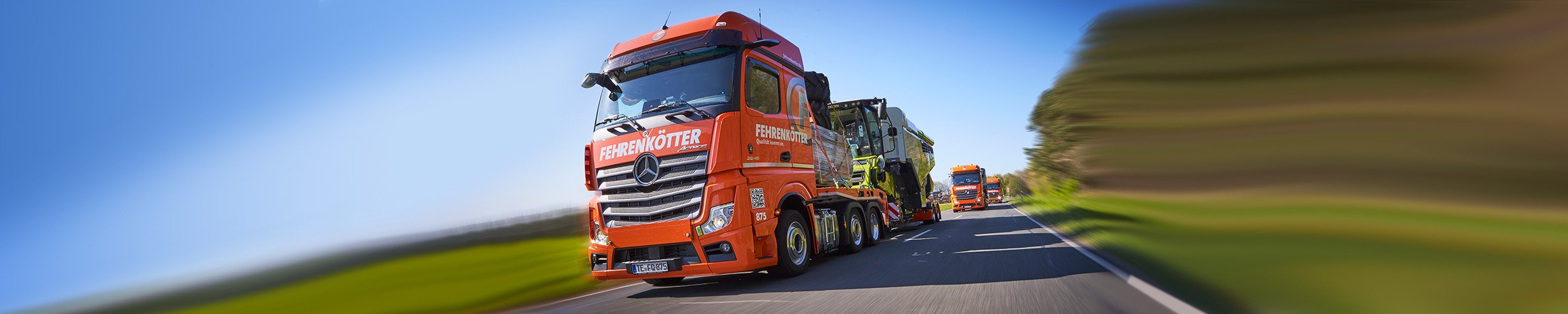 Fehrenkötter-Lkw transportiert einen Mähdrescher auf der Landstraße